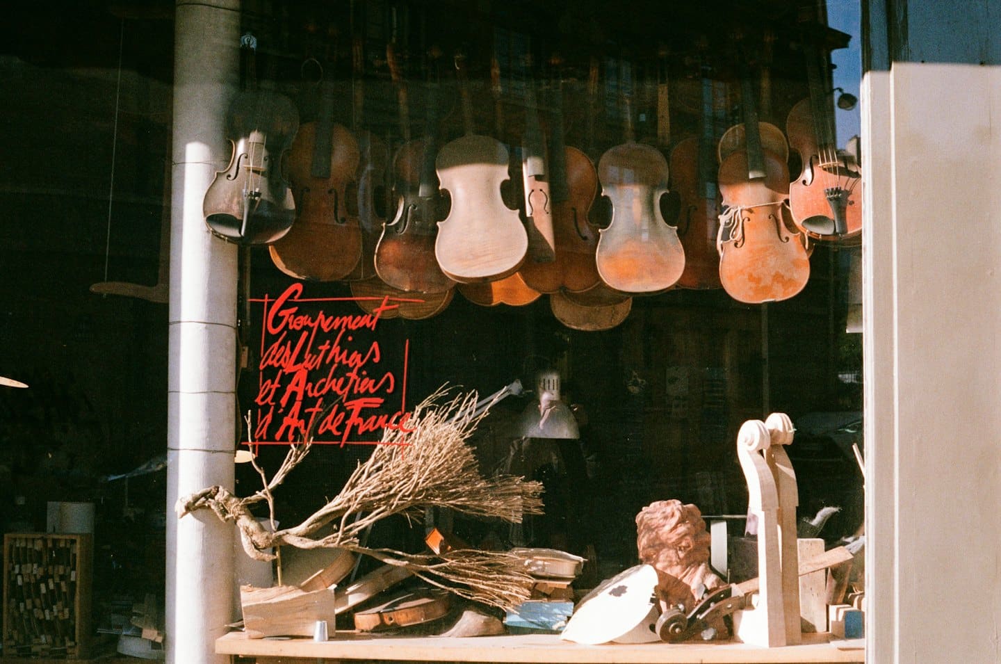 Geigen und Geigenbauerwerkzeuge in einem Schaufenster.