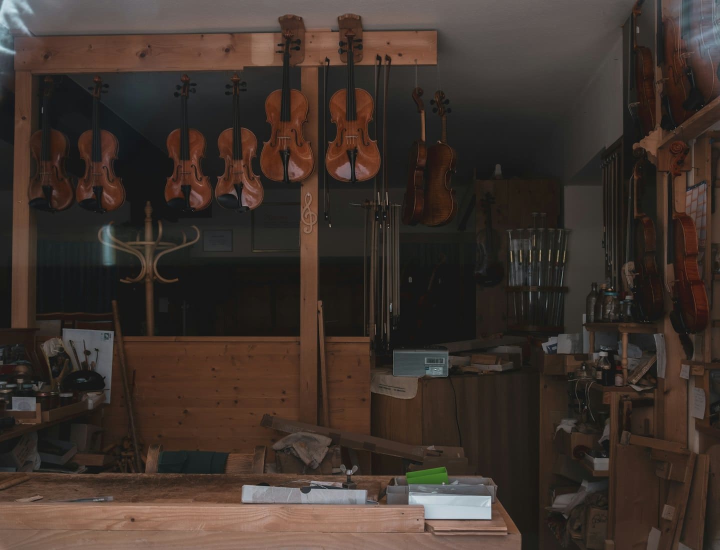 Geigen und Bratschen hängen in der Werkstatt eines gut sortierten Instrumentenbauers.