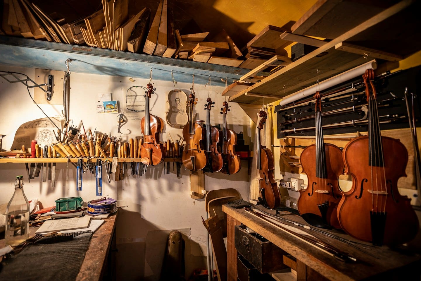 Geigenbauerwerkstatt mit Violinen, Celli und Holzbearbeitungswerkzeugen.